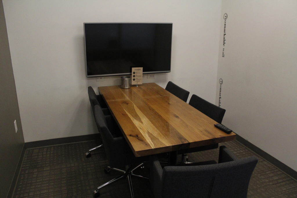 Conference room seating up to 5 people with whiteboard wall