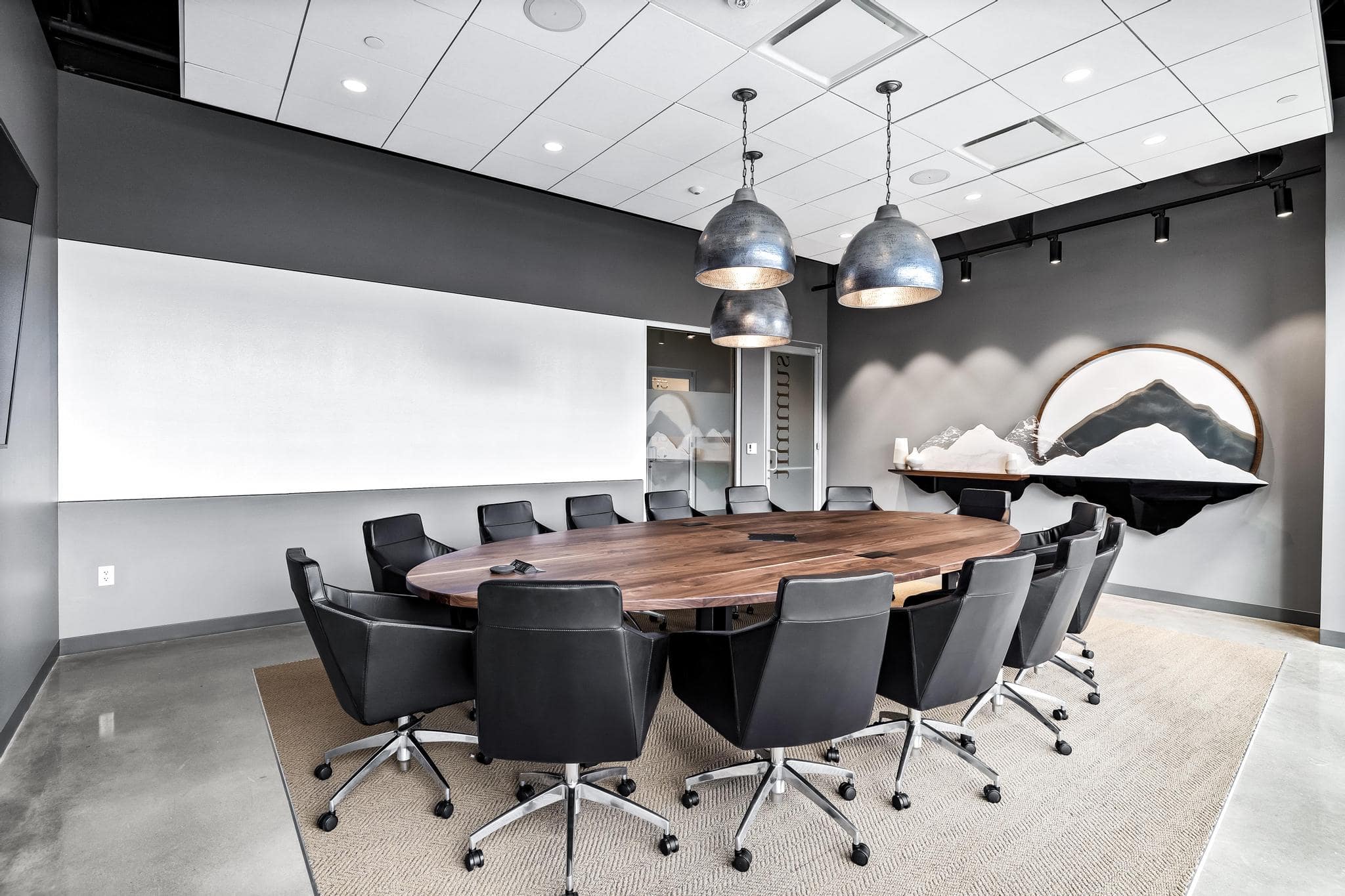 Summit, round boardroom table with 14 chairs, dry erase wall, and projection capabilities